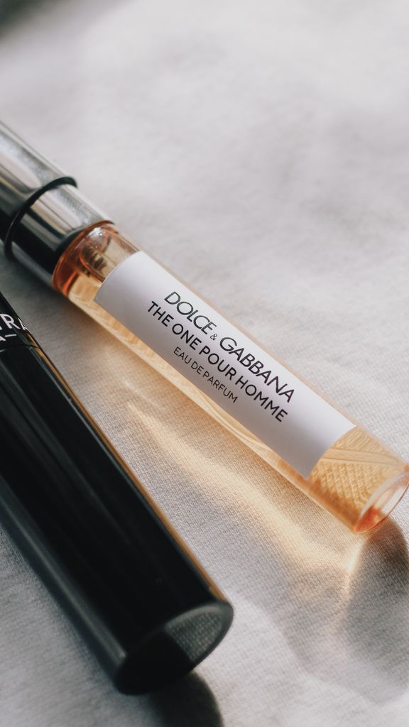 Close-up of two elegant perfume vials on a soft fabric background, showcasing luxury.